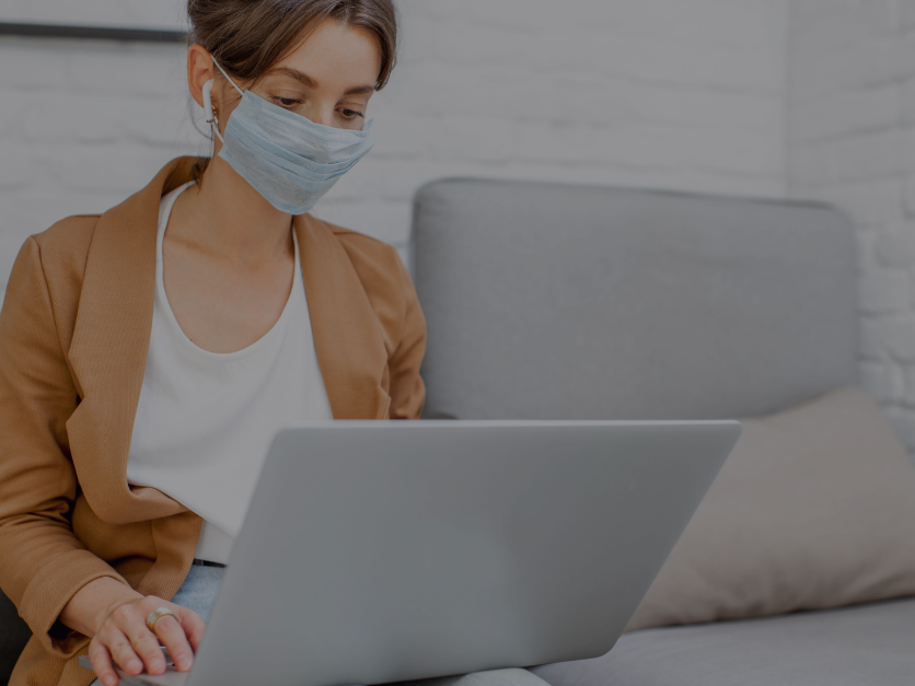 Mitarbeiterin mit Maske im Homeoffice
