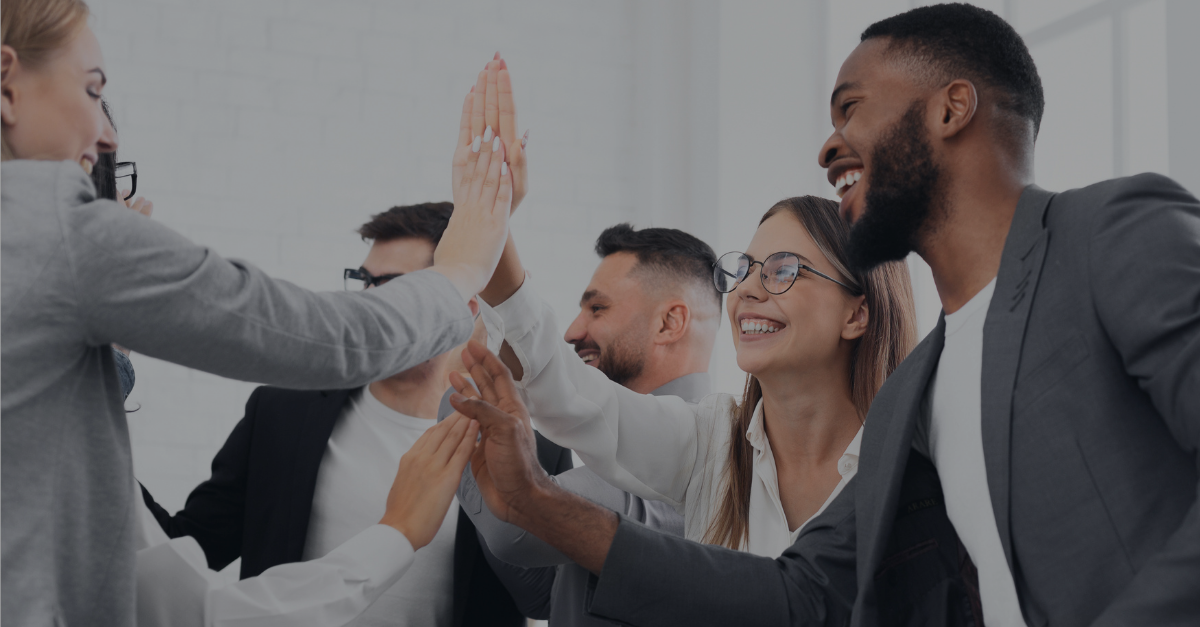 Diverses Team gibt sich einen Highfive bei der Arbeit
